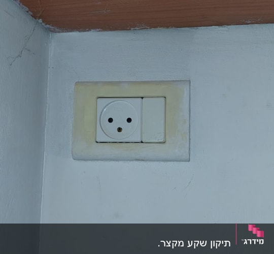 שקע חשמל בקיר לבן עם מתג